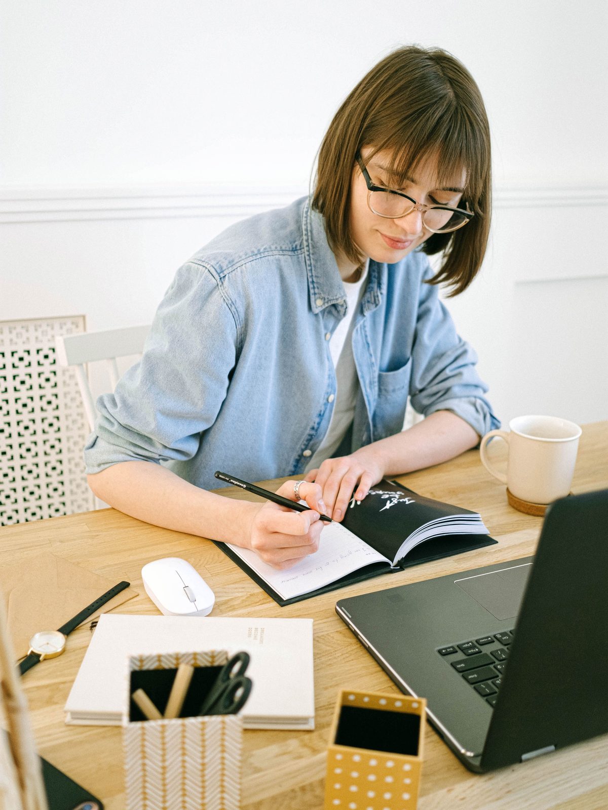 A person mapping out goals in a journal by warm light